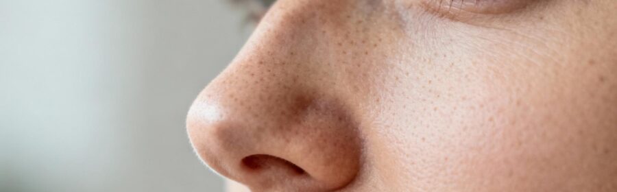 Visage d'une femme européenne avec une peau saine montrant les détails des pores et la texture cutanée du nez