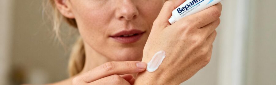 Femme européenne appliquant délicatement de la crème Bepanthen sur une zone de peau sensible atteinte d'eczéma