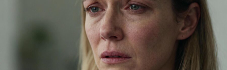 Femme d'âge moyen avec teint pâle et expression fatiguée, montrant des signes de carence en fer et d'anxiété